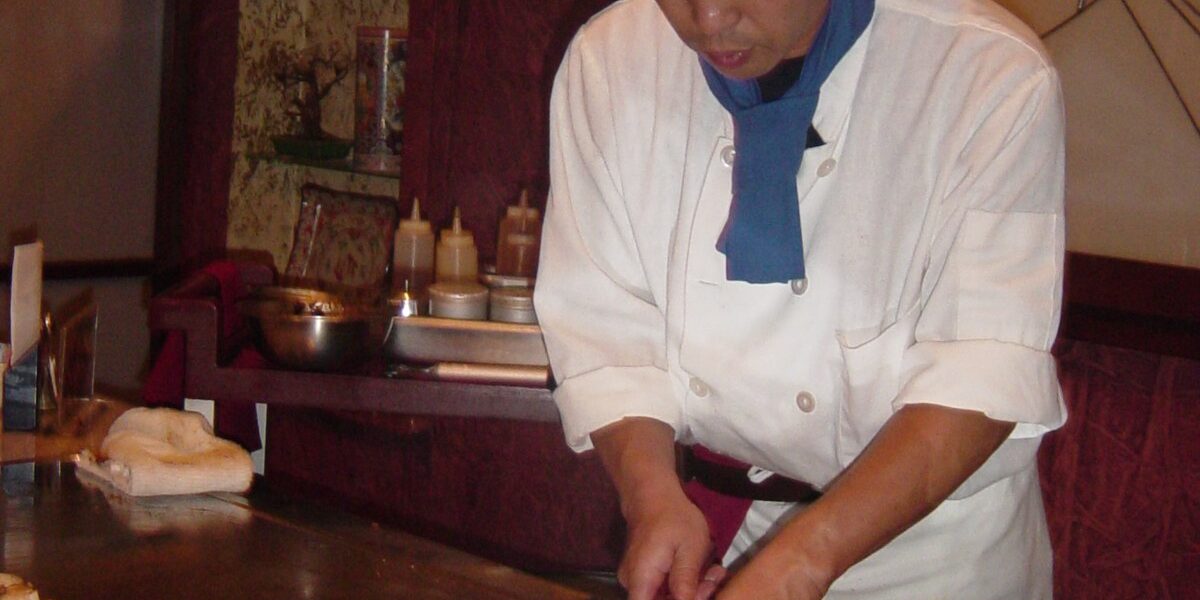 Teppanyaki chef cooking at a hibachi grill in a Japanese steakhouse in the GTA