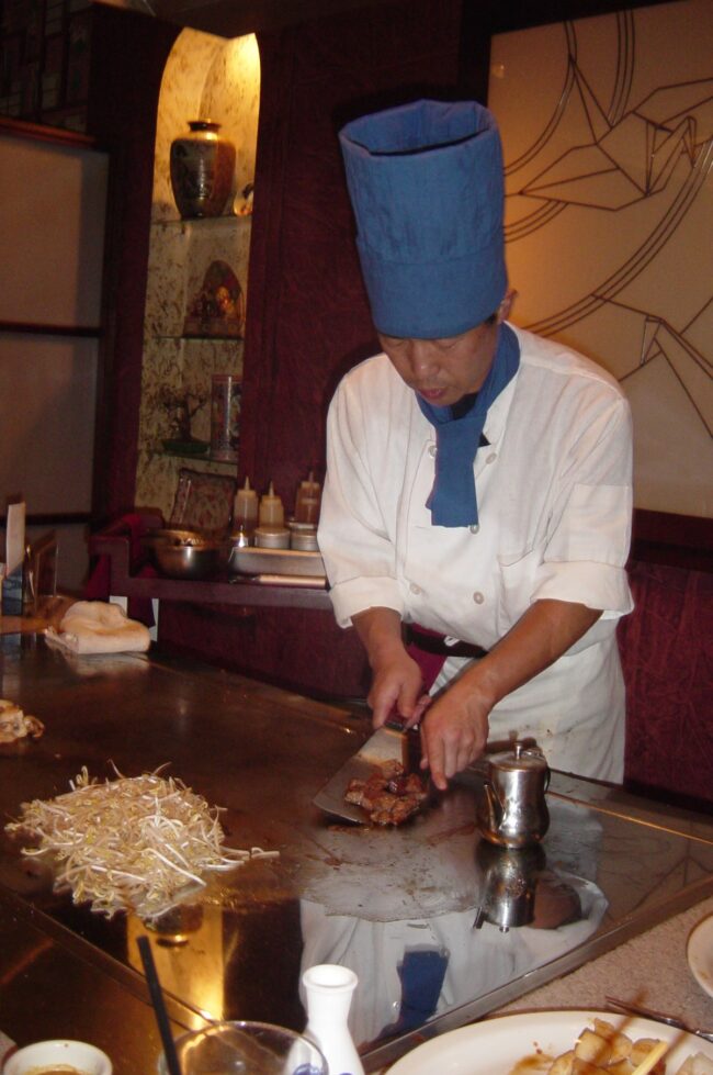 Teppanyaki chef cooking at a hibachi grill in a Japanese steakhouse in the GTA