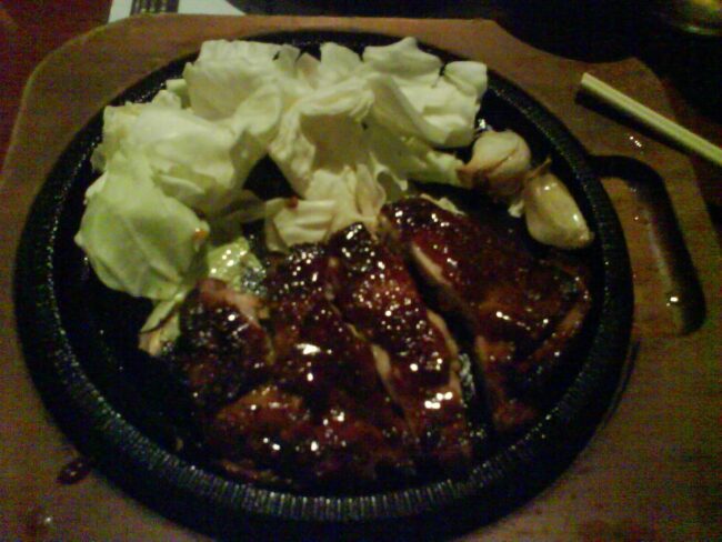 Teppanyaki chicken cooking on a hibachi grill with vegetables for a dietary-friendly menu