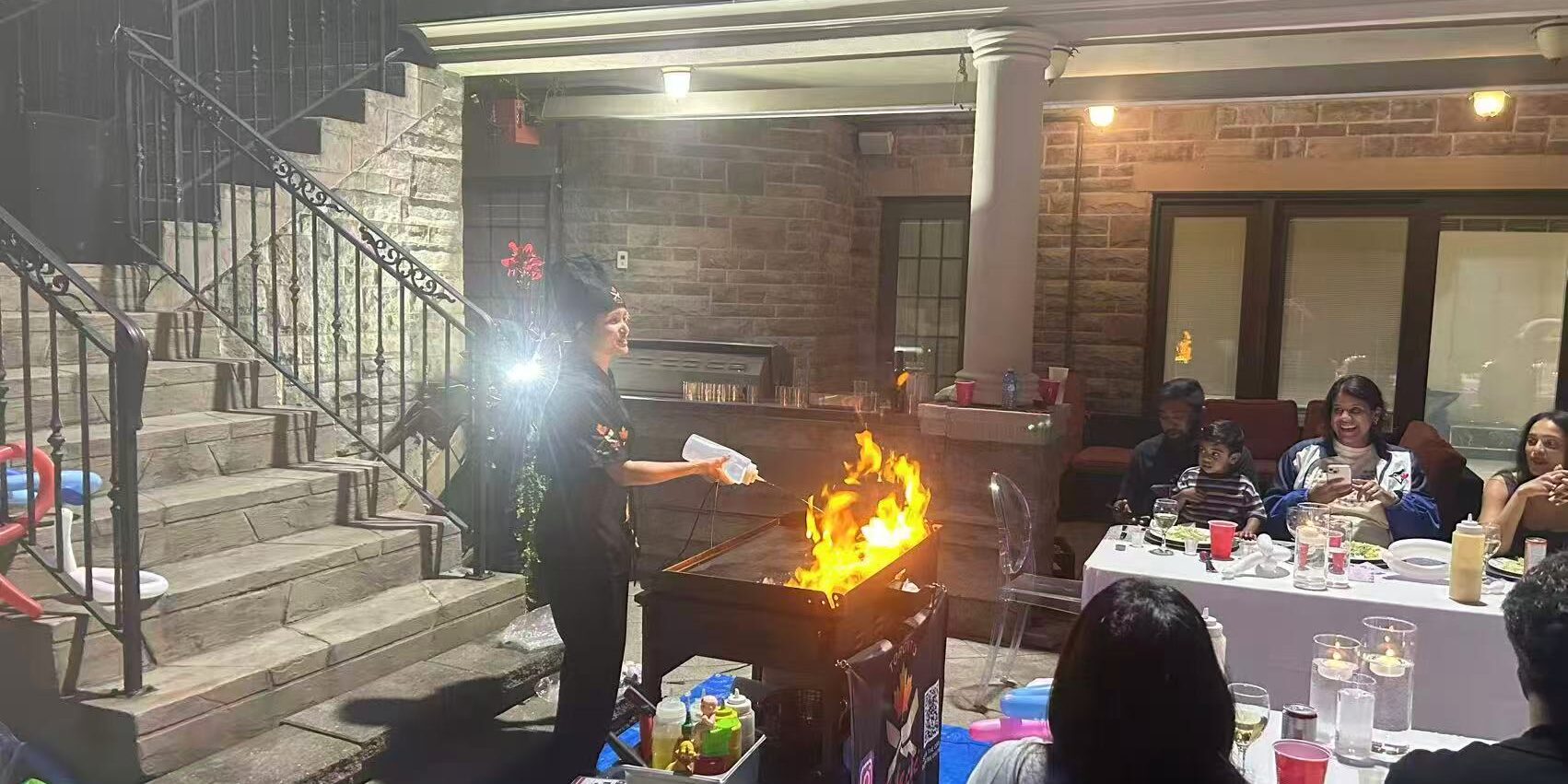 Brampton Thanksgiving weekend hibachi catering Hibachi chef cooking with a flame under a covered patio for a Brampton Thanksgiving weekend family dinner in the GTA