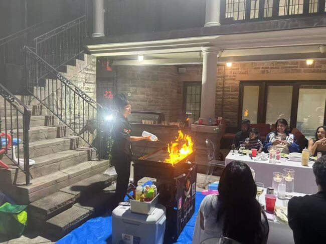 Hibachi chef cooking with a flame under a covered patio for a Brampton Thanksgiving weekend family dinner in the GTA